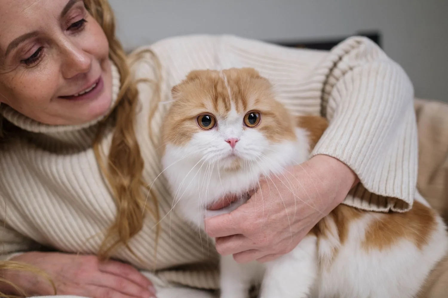 A woman holding her cat close at home